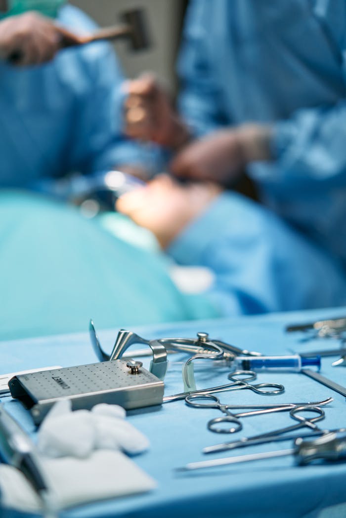 Close-up of surgical tools with surgeons in the background in an operating room.